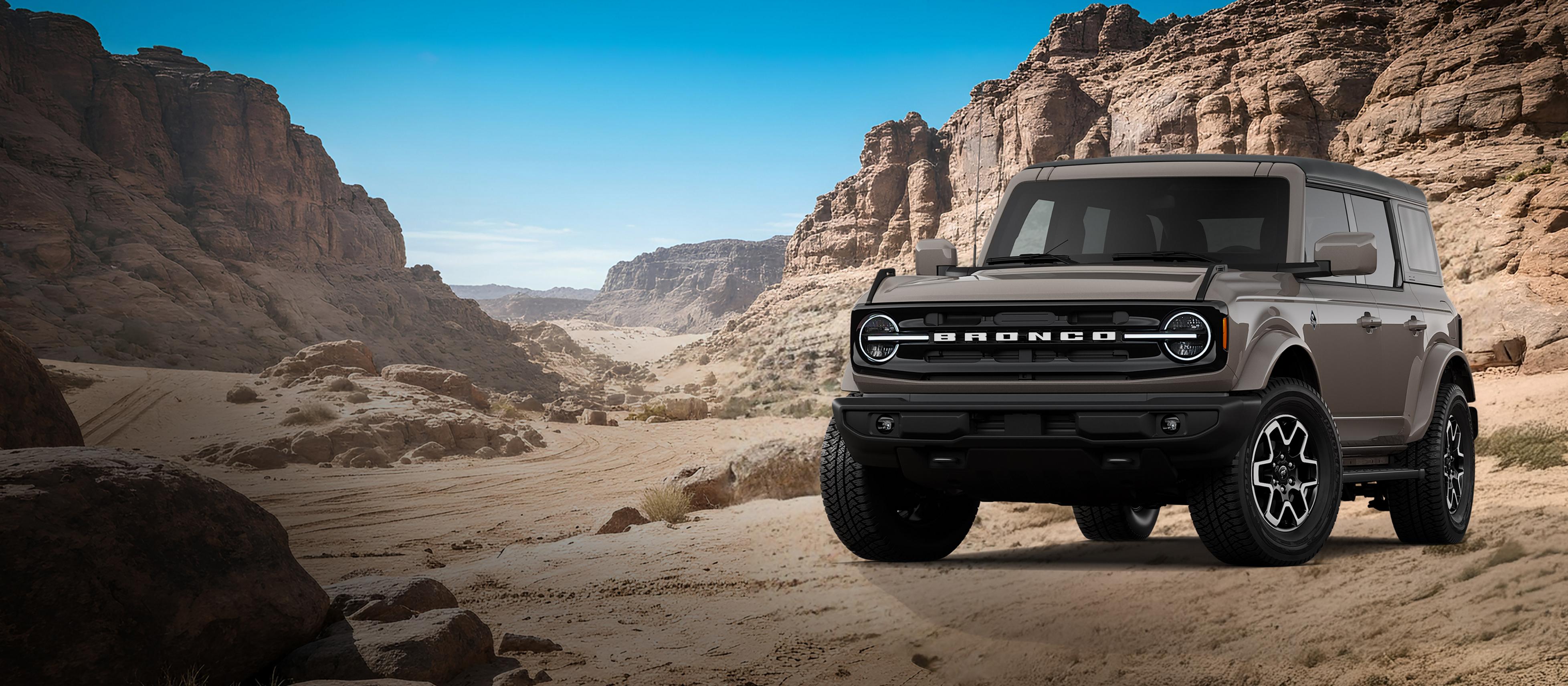 A 2026 Ford Bronco® Outer Banks model shown in Marsh Gray parked on a rocky expanse