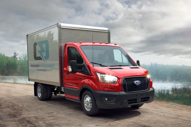 2025 Ford Transit® Chassis Cab model with box truck upfit being driven on a dirt road near a lake
