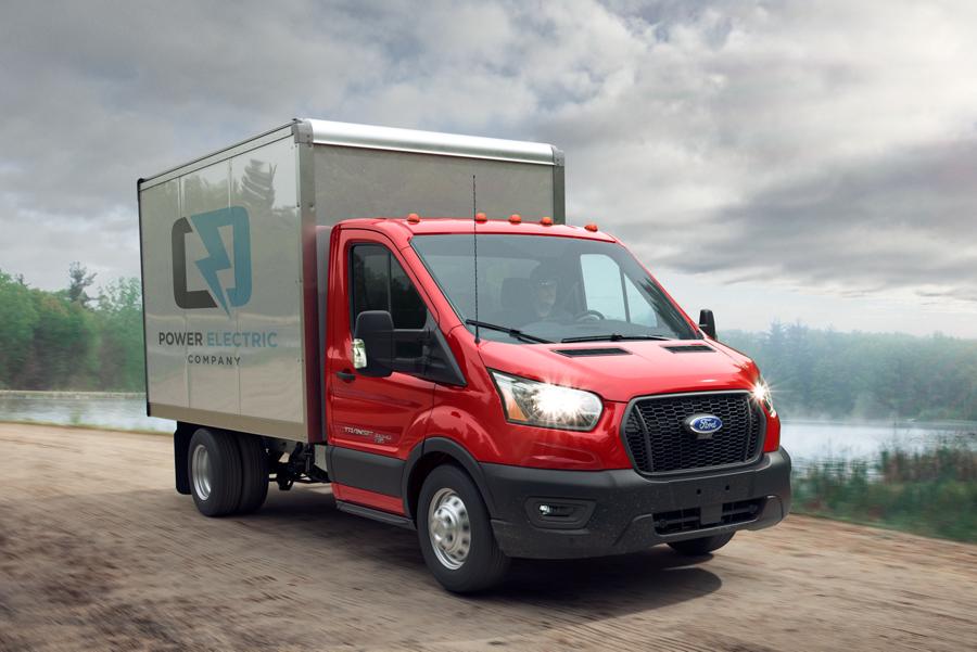 2025 Ford Transit® Chassis Cab model with box truck upfit being driven on a dirt road near a lake