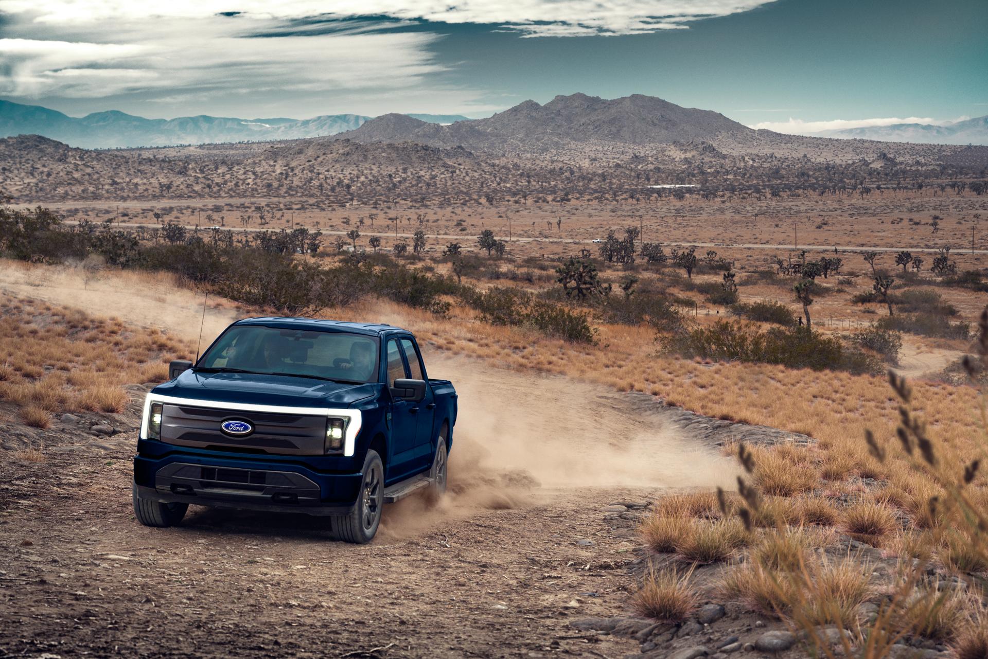 The Ford F-150® Lightning truck kicks up dust on a remote desert track