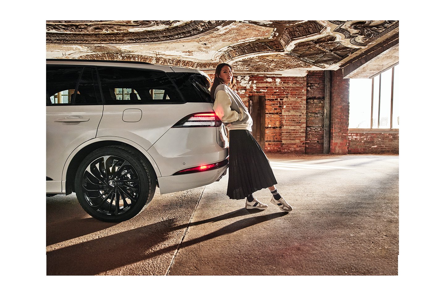 Une femme appuyée contre l'arrière du Lincoln Aviator 2025