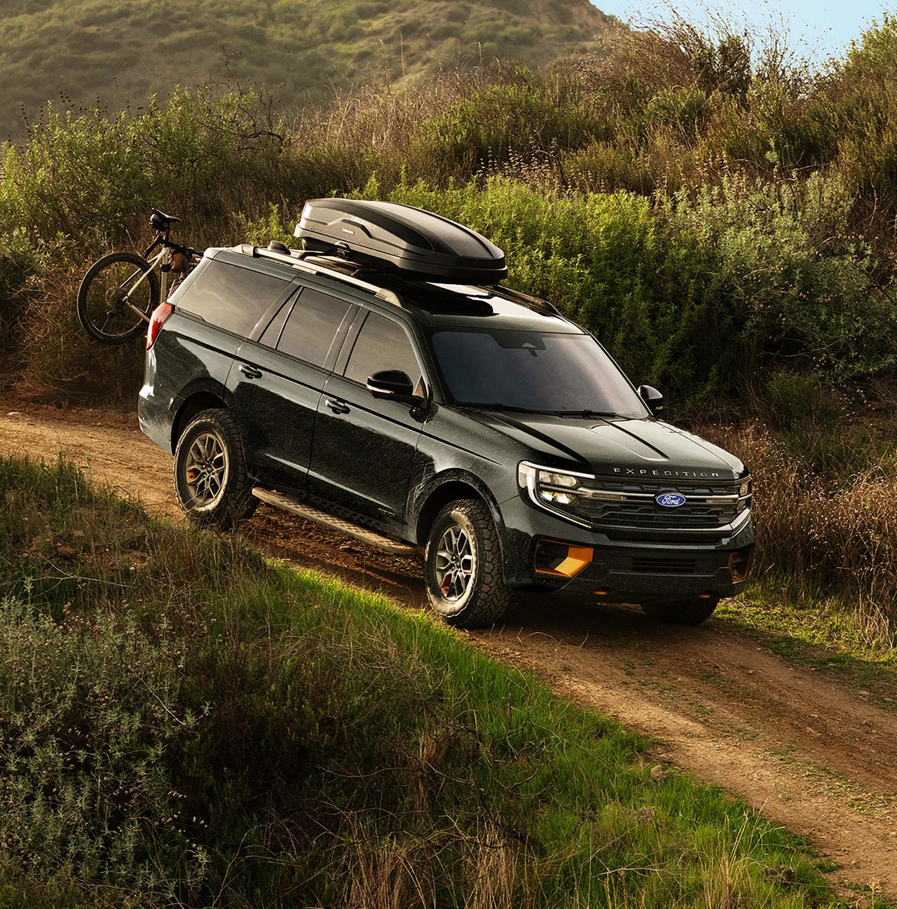 2027 Ford Expedition® Tremor® SUV with optional equipment and available Ford accessories shown being driven on a dirt road