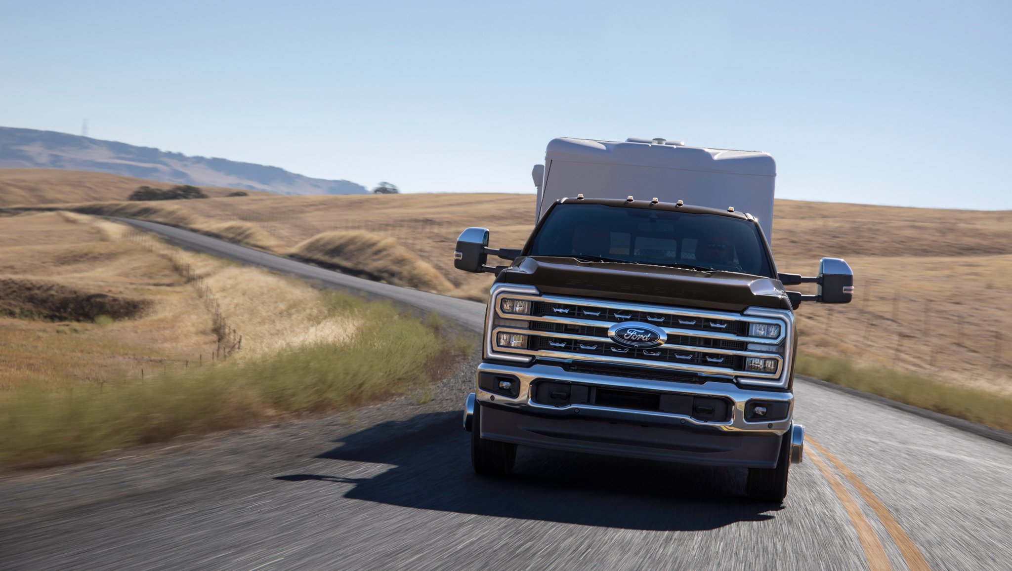 Front view of a 2025 Ford Super Duty® F-350® LARIAT truck pulling a trailer