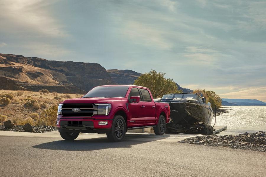 2026 Ford F-150® STX® FX4 pickup in Ruby Red Metallic pulling a boat out of the water