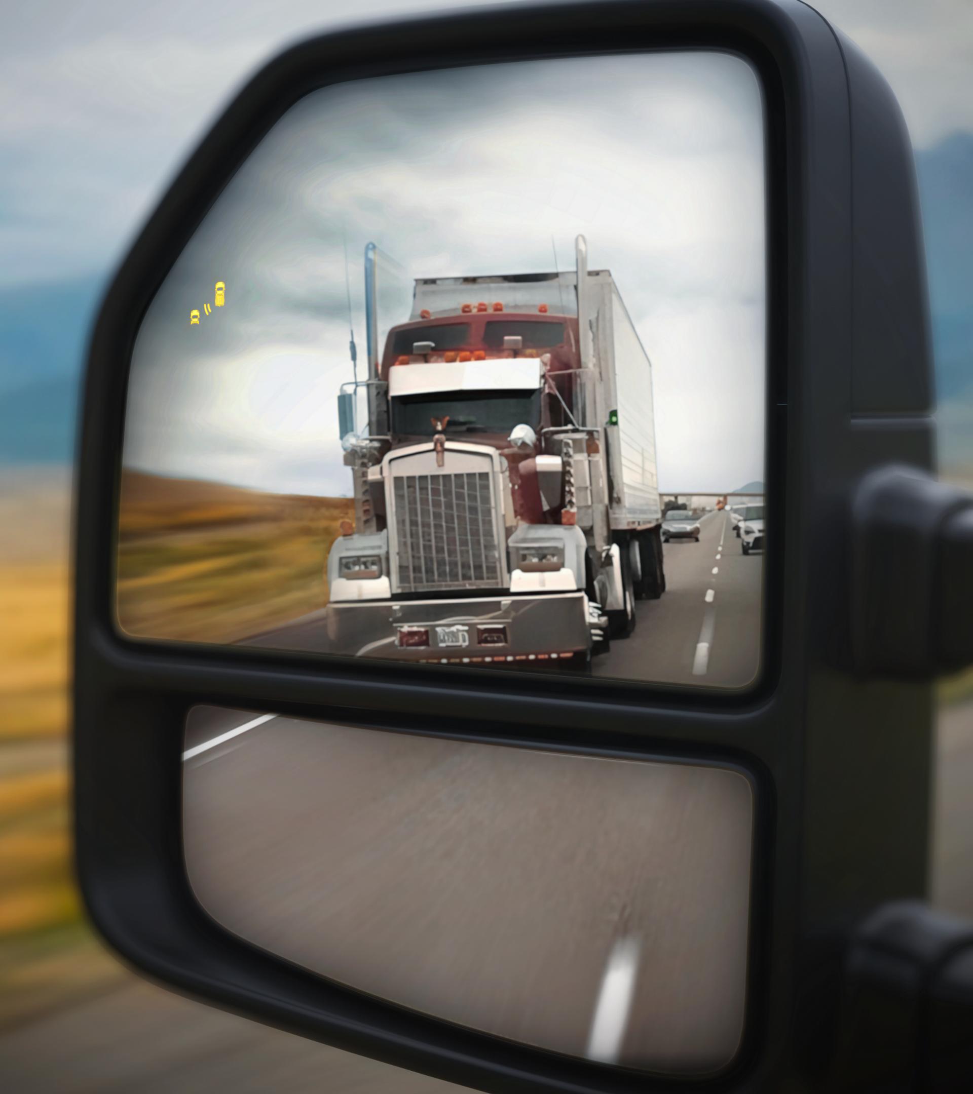 View of the 2026 Ford Super Duty® pickup left side view mirror with a semi truck in the reflection