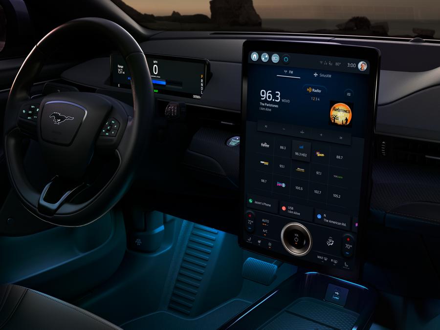 The interior of a Ford Mustang Mach-E, showing a screen displaying a SYNC 4A menu for choosing a radio station.