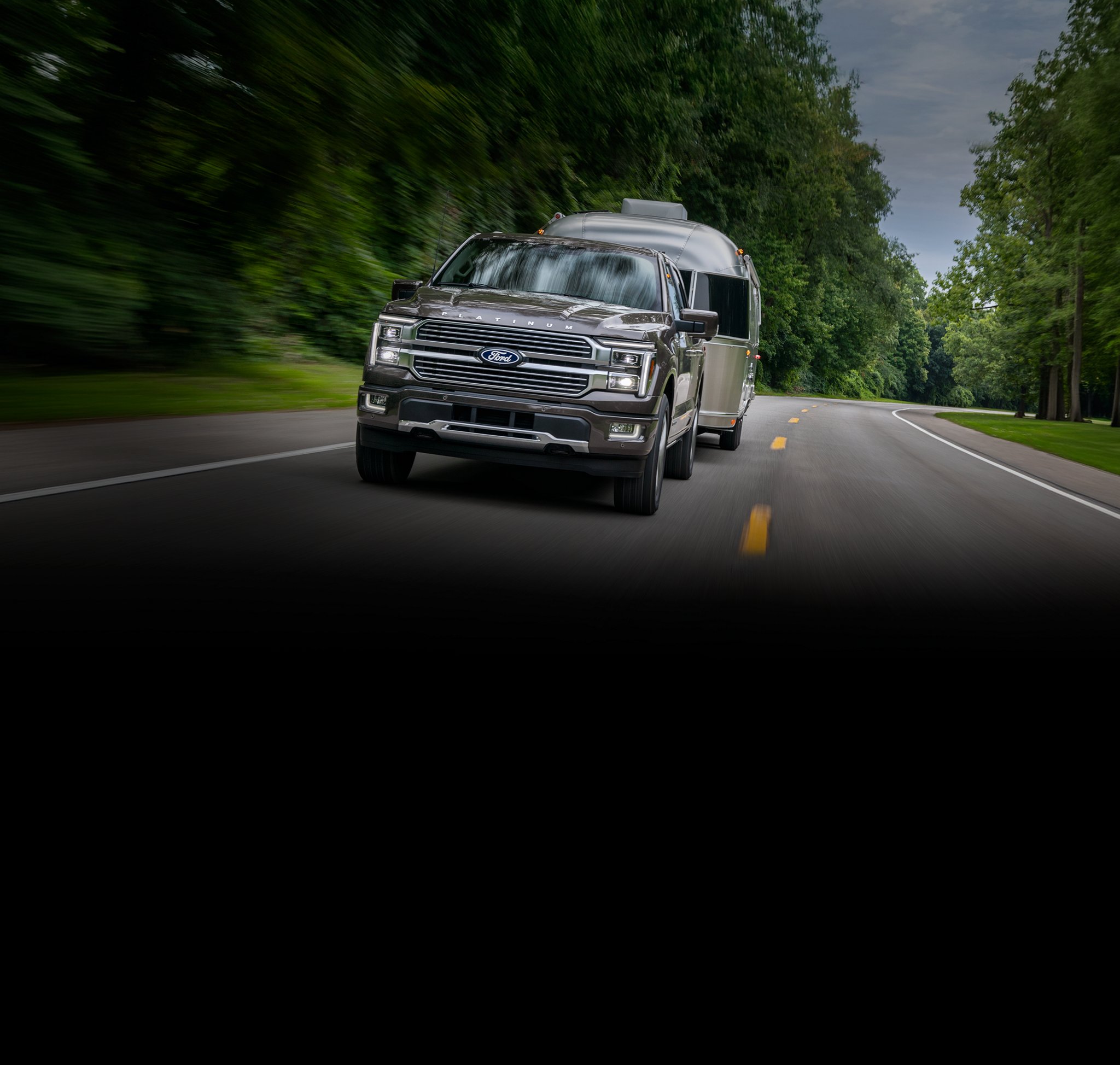 2026 Ford F-150® Platinum® truck in Marsh Gray pulling a camper