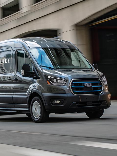 Una van Ford E-Transit™ 2026 andando por una calle urbana