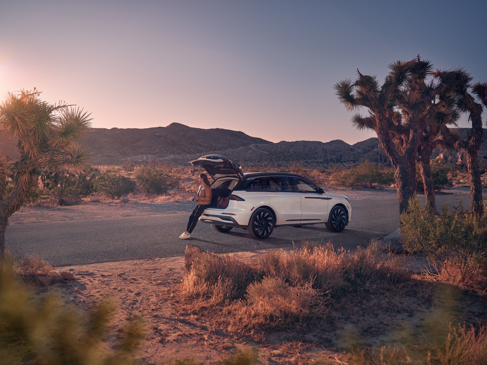 A woman sits in the rear cargo area of a 2026 Lincoln Nautilus® SUV