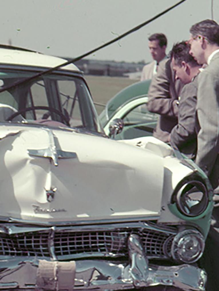 A group of men looking at two vehicles that crashed