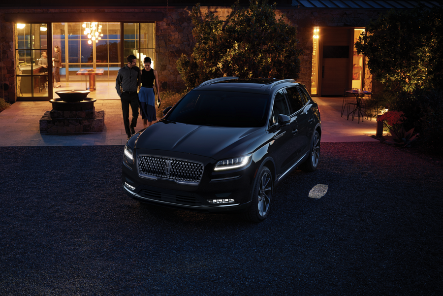 Two people are shown approaching a parked Lincoln Nautilus.