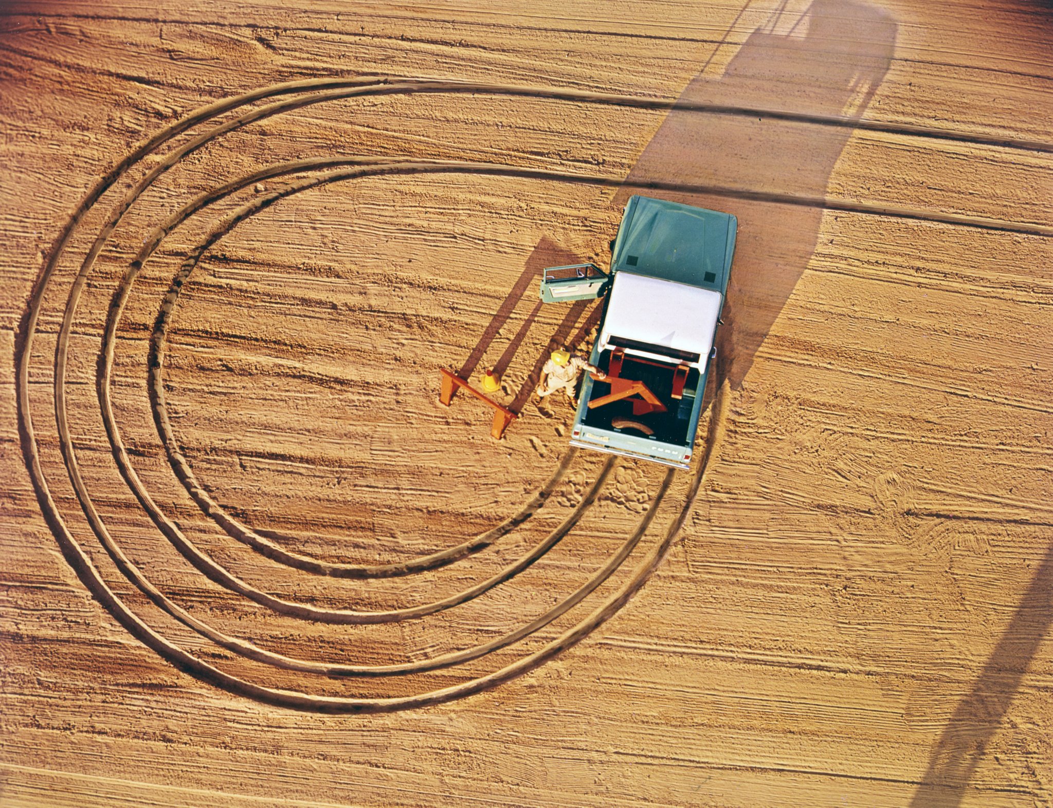 A man unloading wood from the back of a 1969 Ford Bronco Pickup in Lunar Green