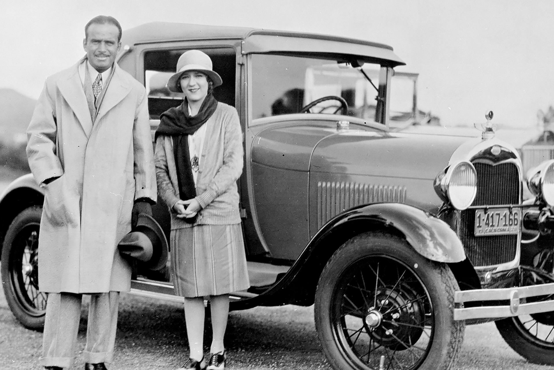 A black and white photo of Doug Fairbanks and Mary Pick with a 1928 Ford Model A Sport Coupe