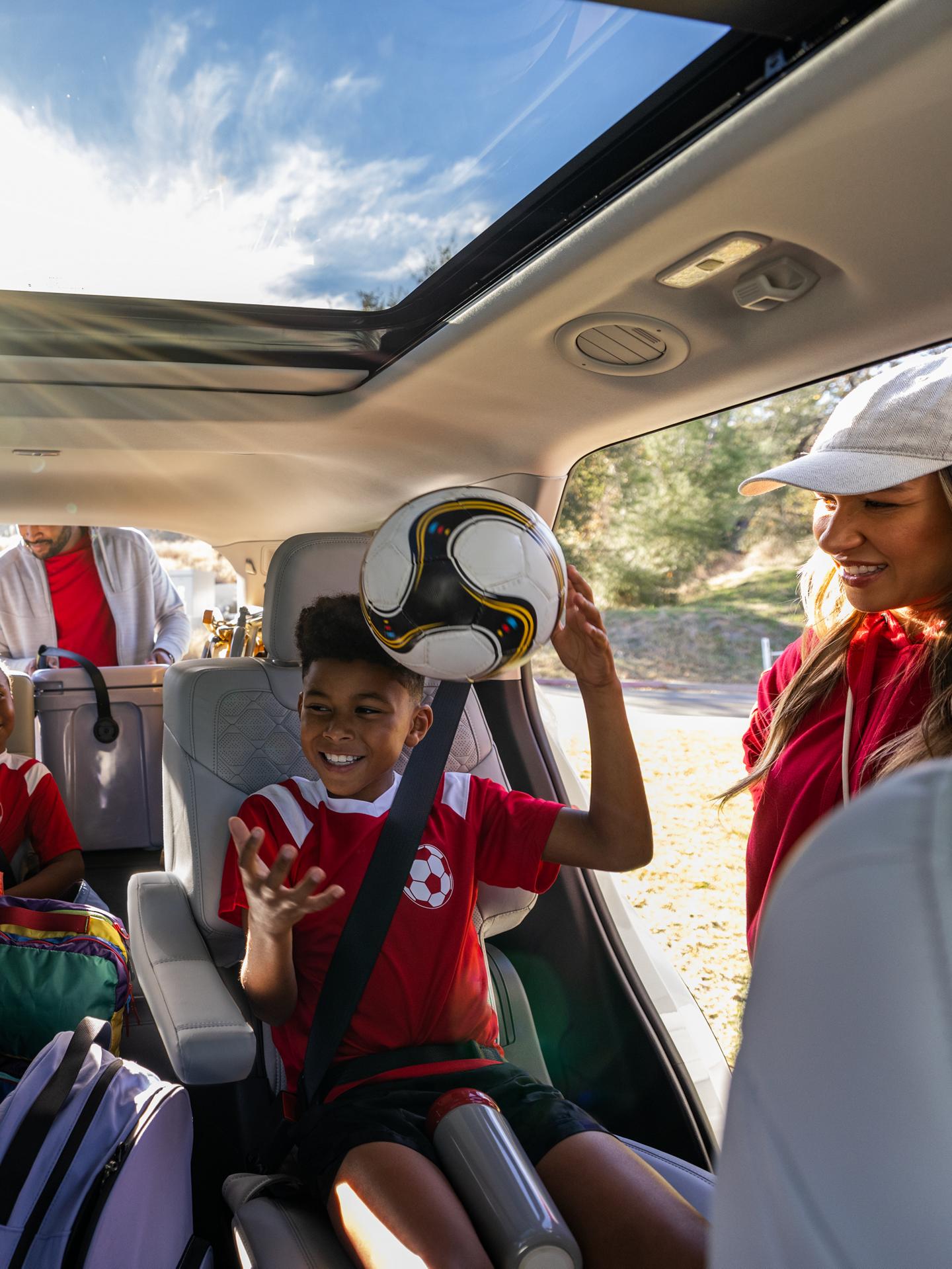 A family loads up their Ford vehicle after a soccer game on a sunny day