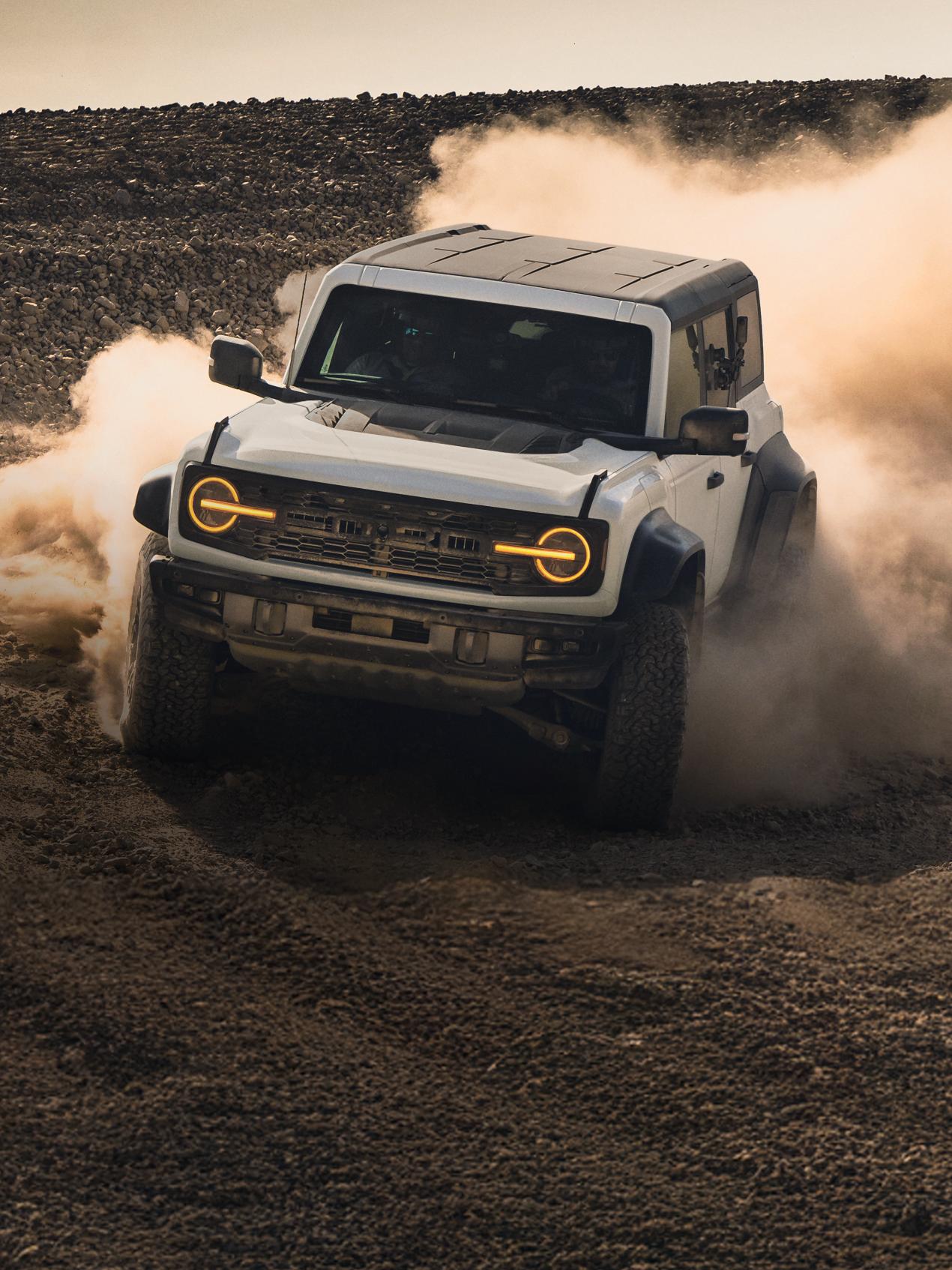 A 2026 Ford Bronco® SUV kicking up dust in a field