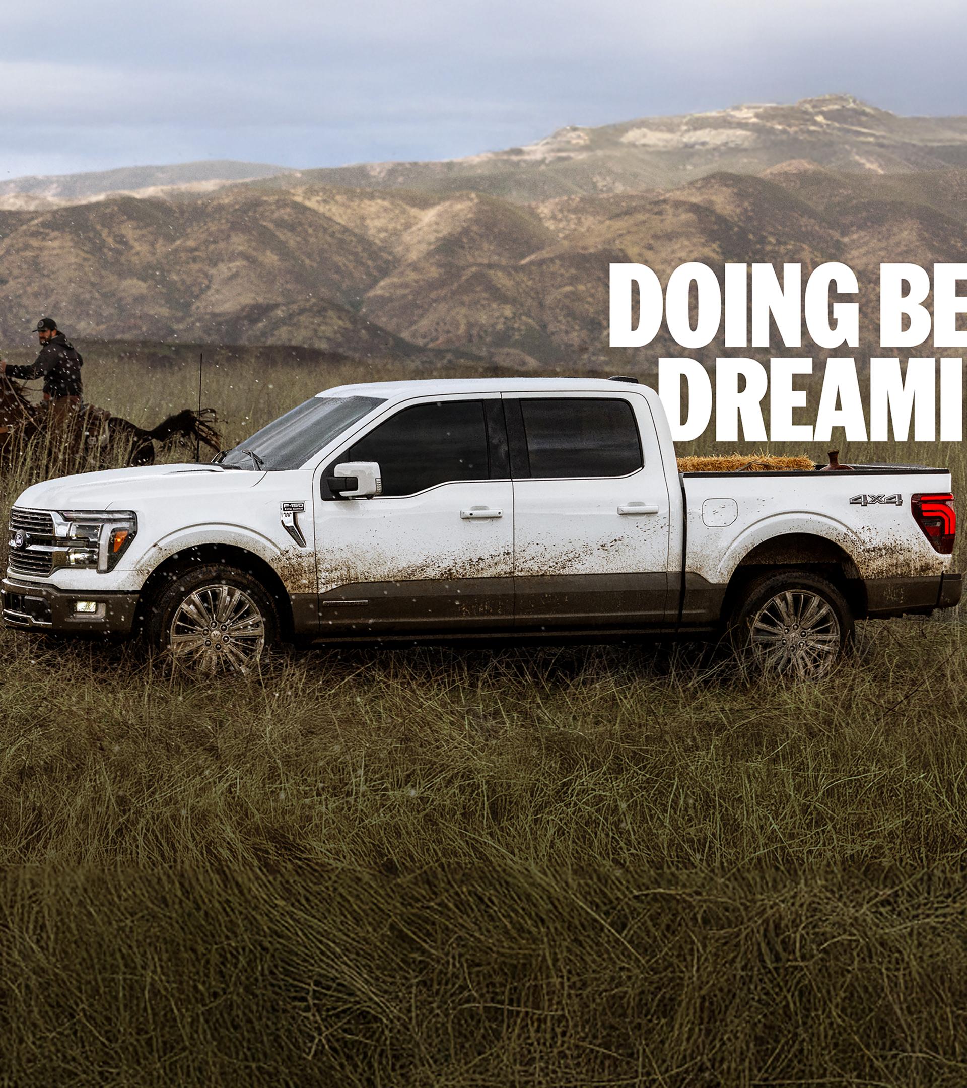 A mud-splattered Ford F-150® pickup out on a ranch with a rider on horseback in the background