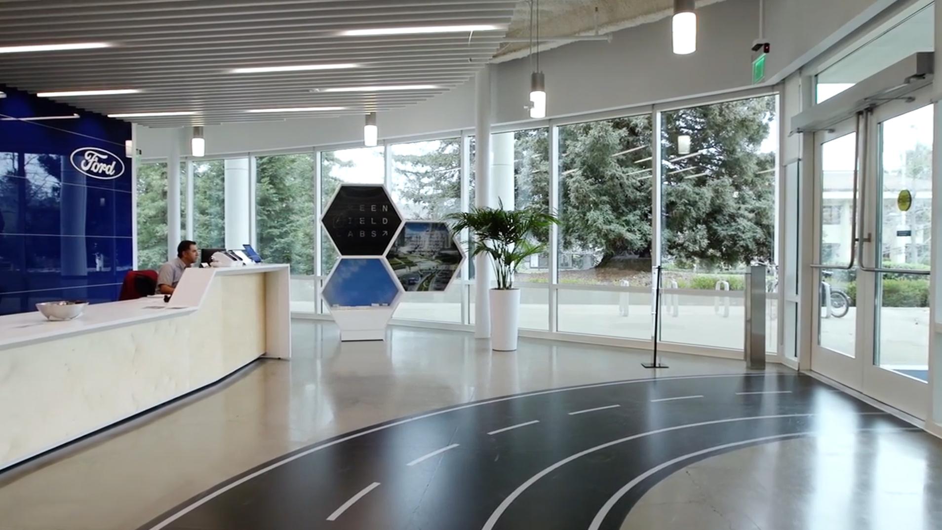 A graphic of a road on the floor draws visitors into the entry way of the Greenfield Labs building