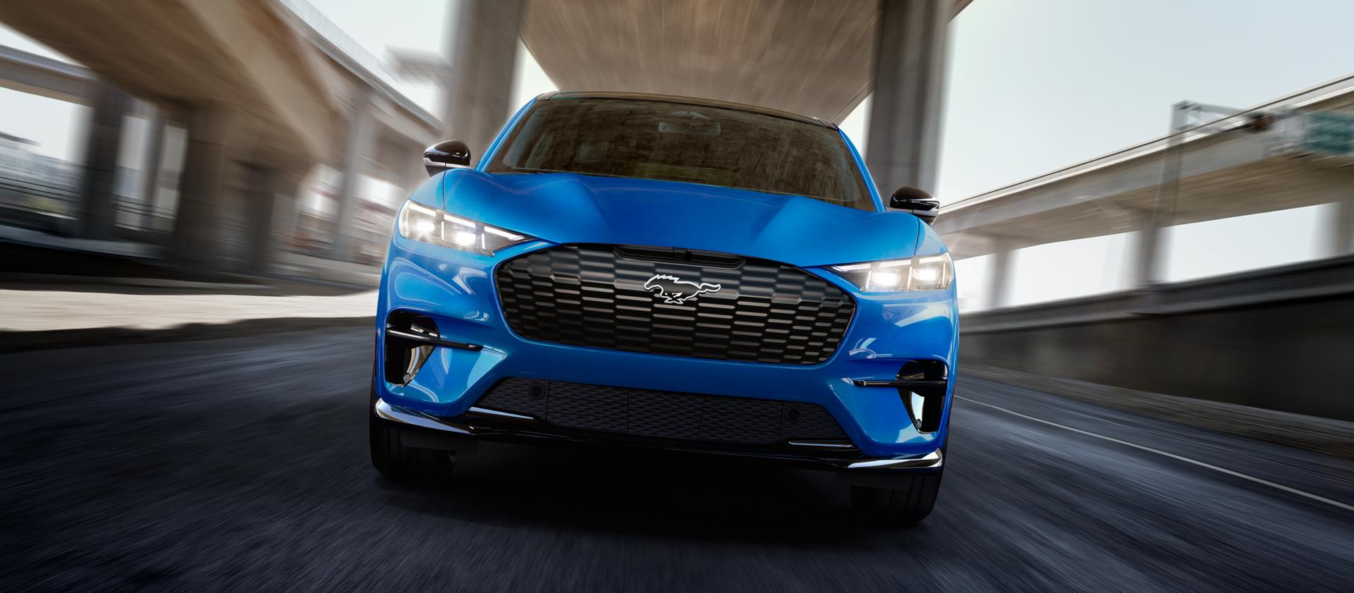 Front view of a 2025 Ford Mustang Mach-E® GT model being driven on a freeway with a blurred background