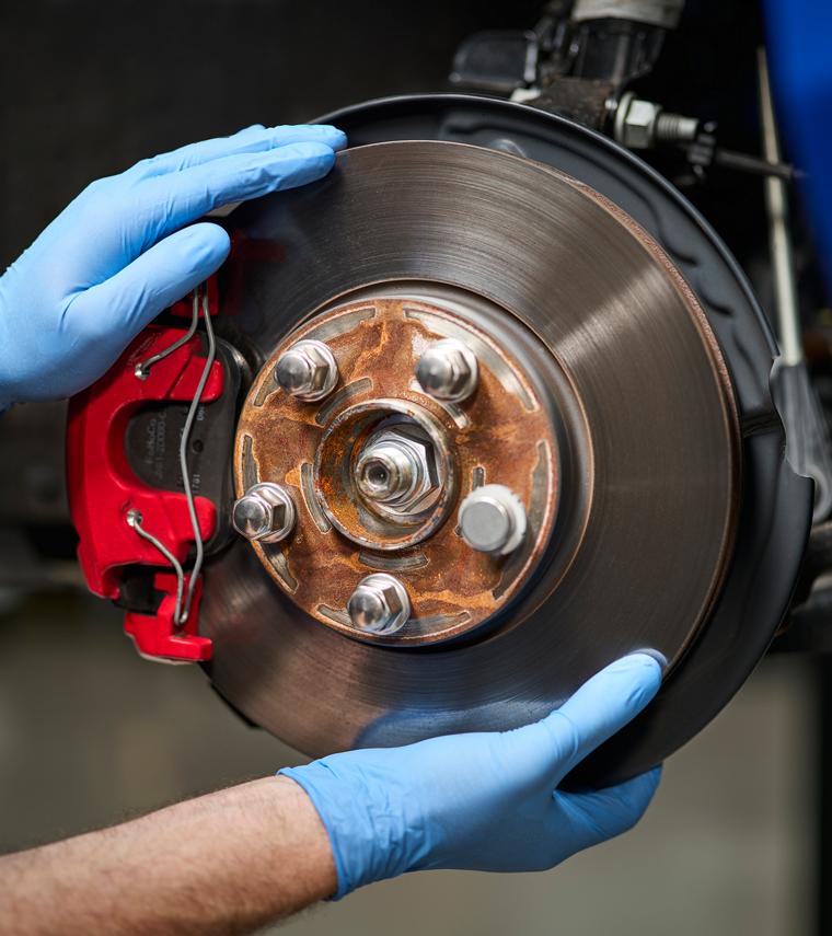 A Ford mechanic working on the brakes of a Ford vehicle.