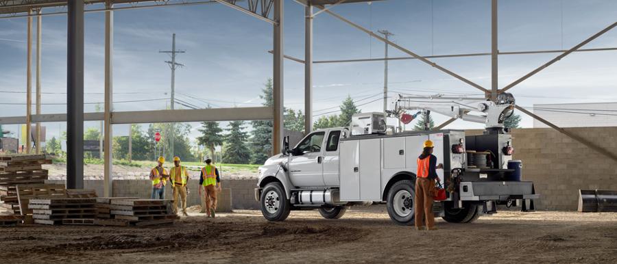 Workers near 2026 Ford F-750® SuperCab in Oxford White with mechanic truck upfit parked at construction site