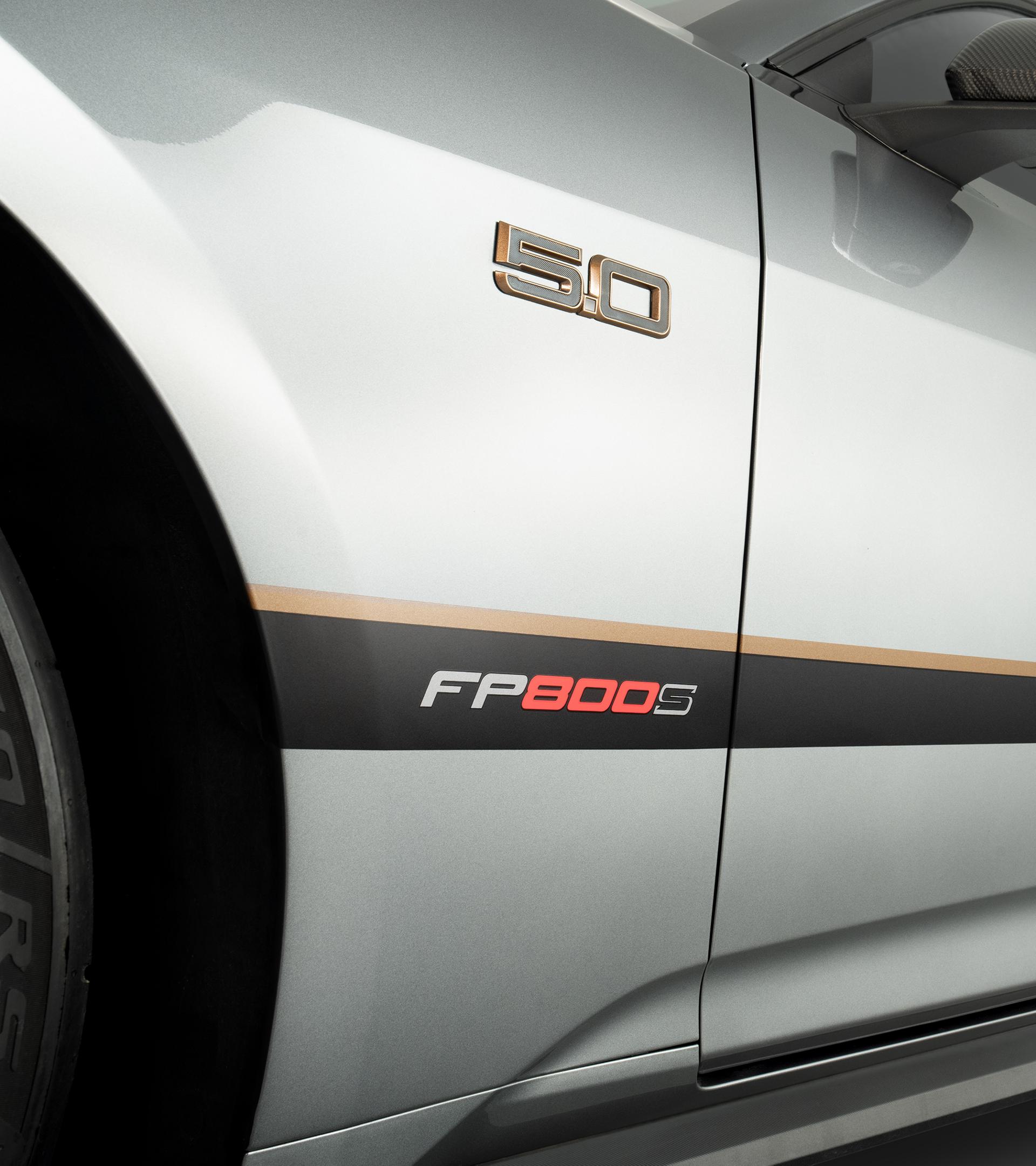 Bronze 5.0 fender badge on the front quarter panel of a gray Mustang, above the FP800S bodyside graphic