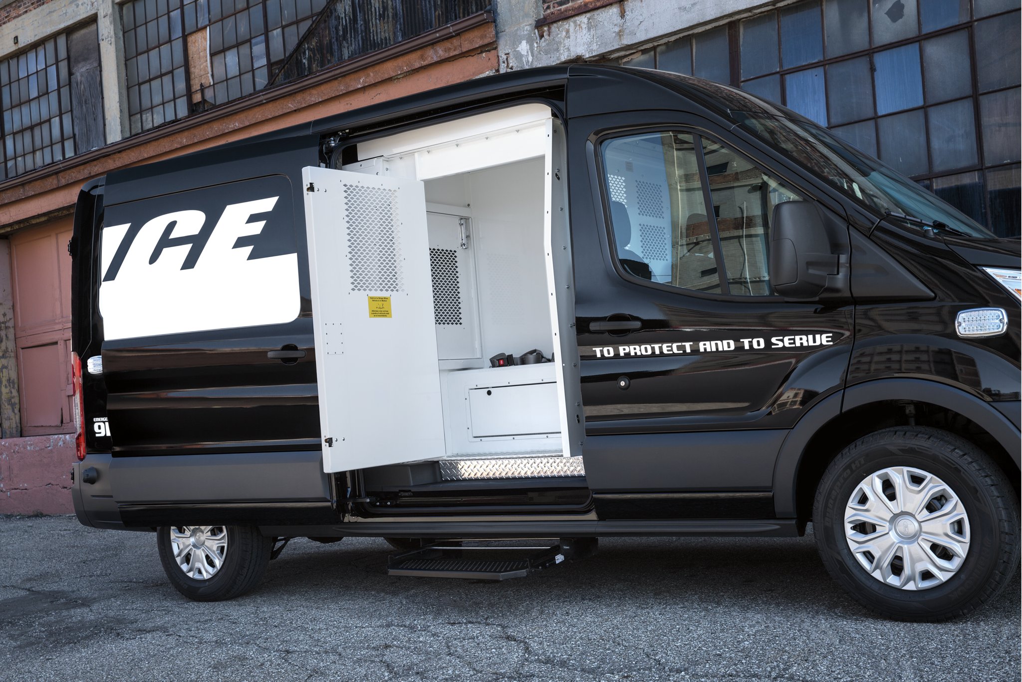 An open door reveals a side prisoner compartment of the twenty twenty ford transit prisoner transport vehicle 