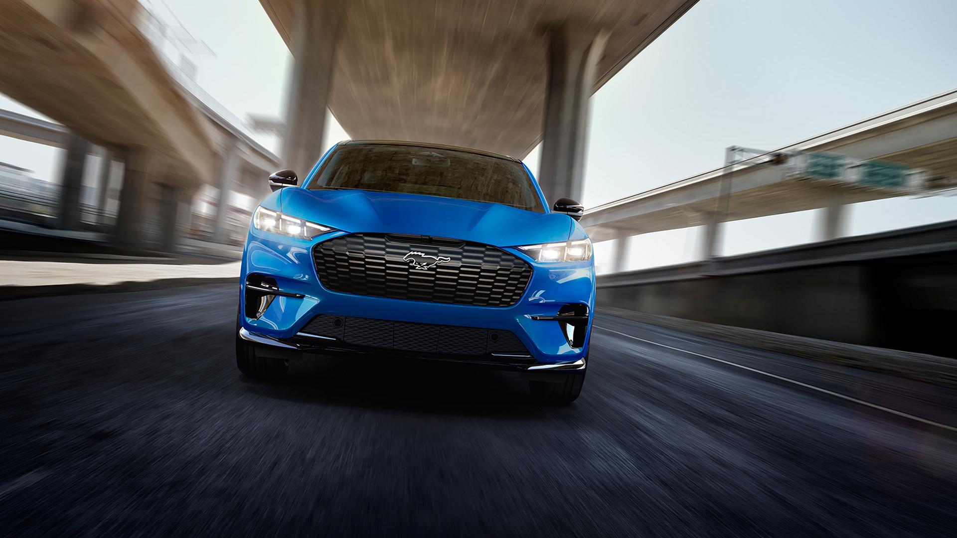 2026 Ford Mustang Mach-E® GT model being driven on a freeway with a blurred background