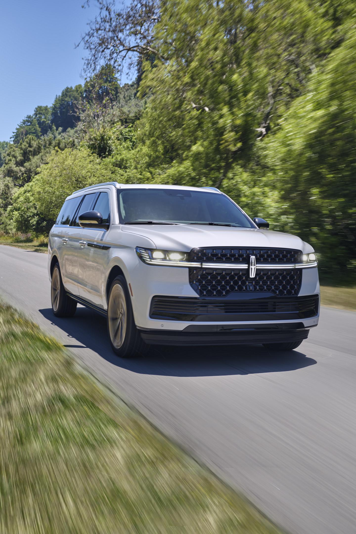 A 2025 Lincoln Navigator® driving down a tree-lined street
