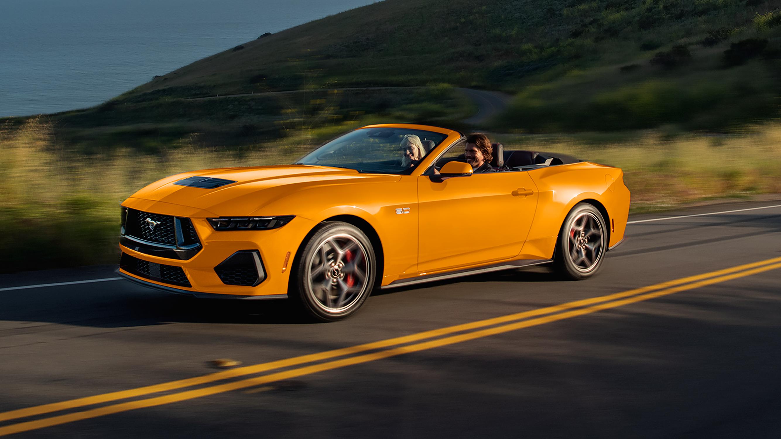 Two people driving in a 2026 Ford Mustang® GT convertible