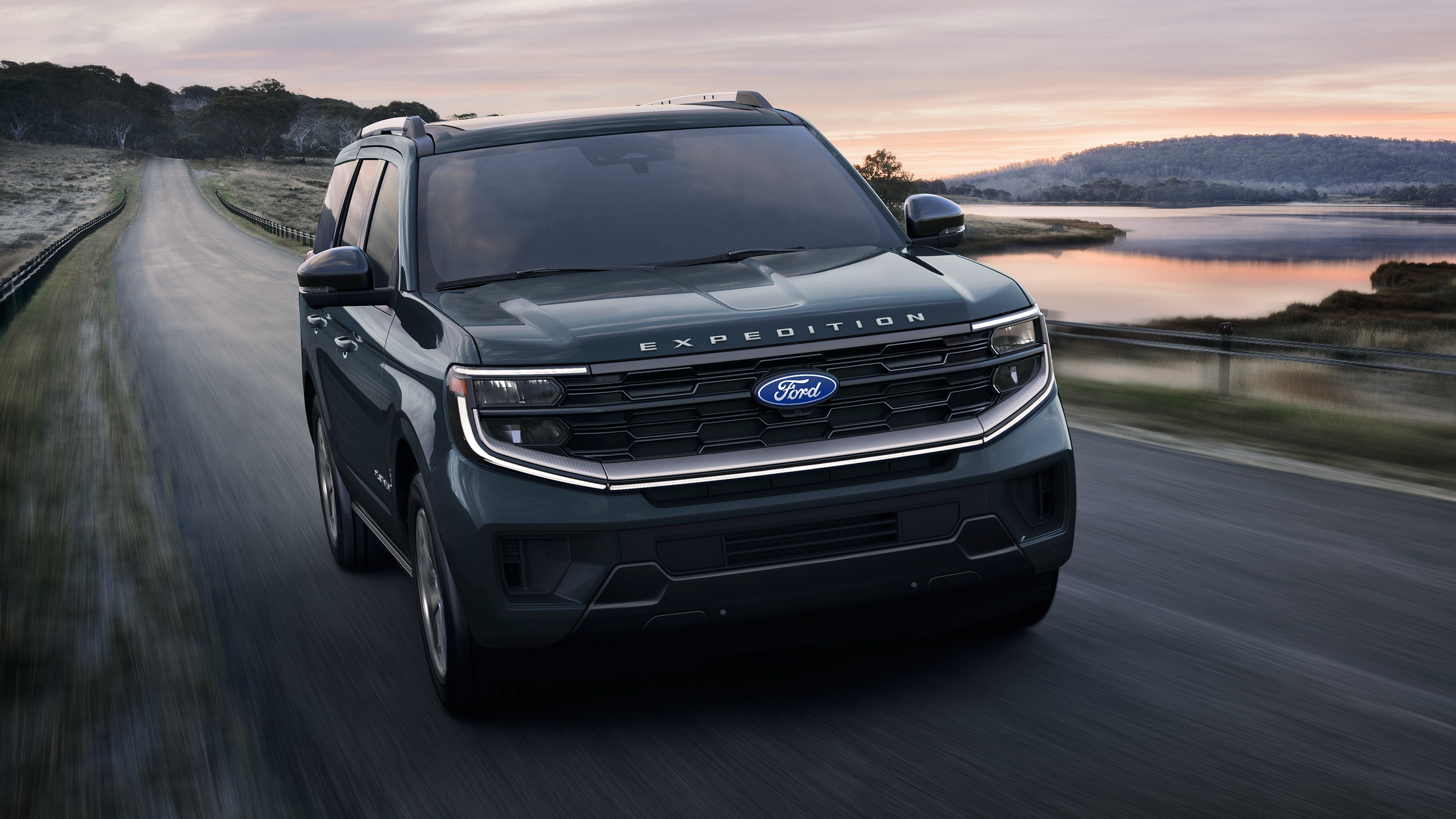 2027 Ford Expedition® Platinum® SUV with available Platinum® Ultimate Package being driven on a lakeside highway