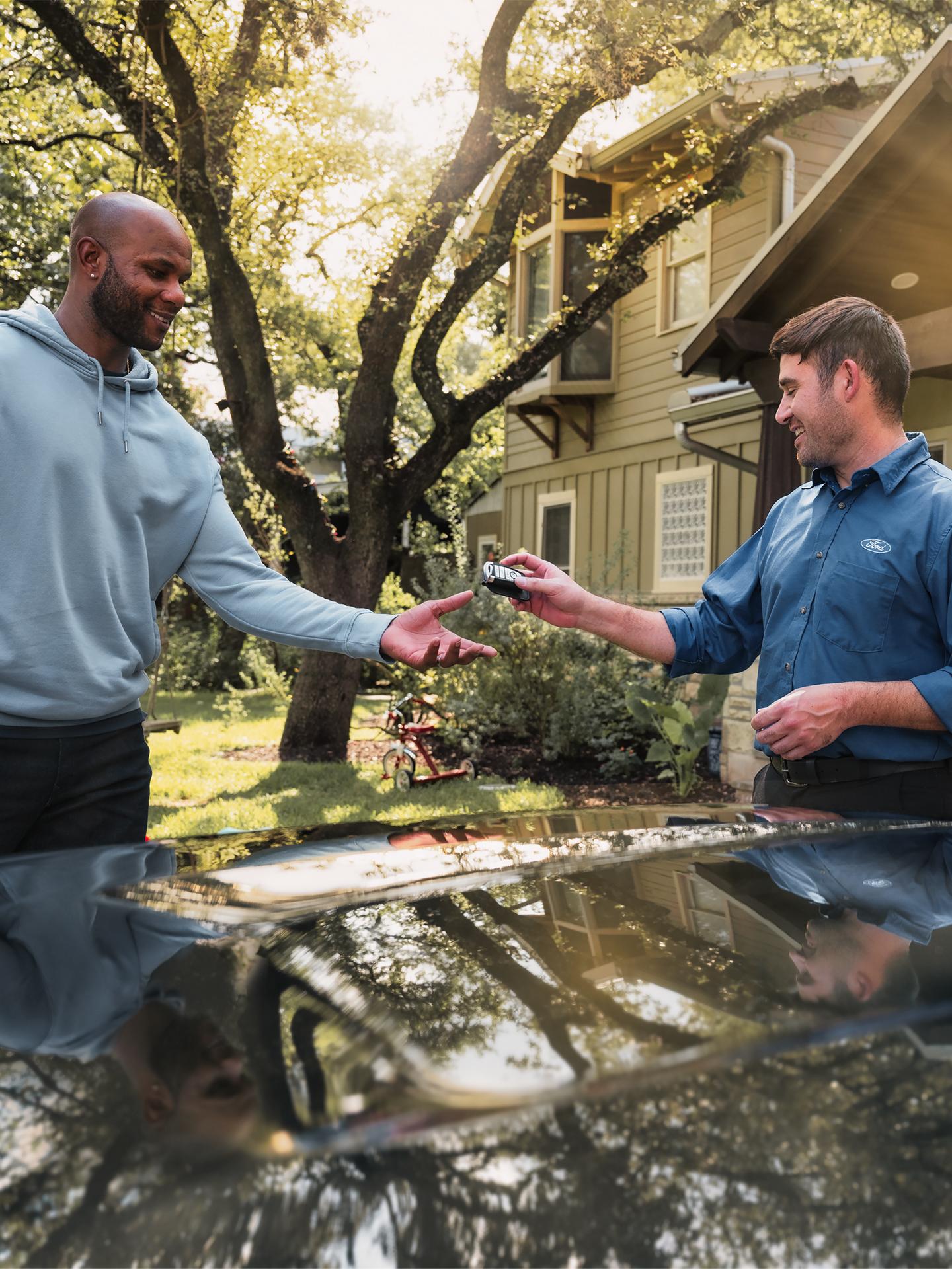 Un associé Ford remet à un conducteur le porte-clés de son véhicule