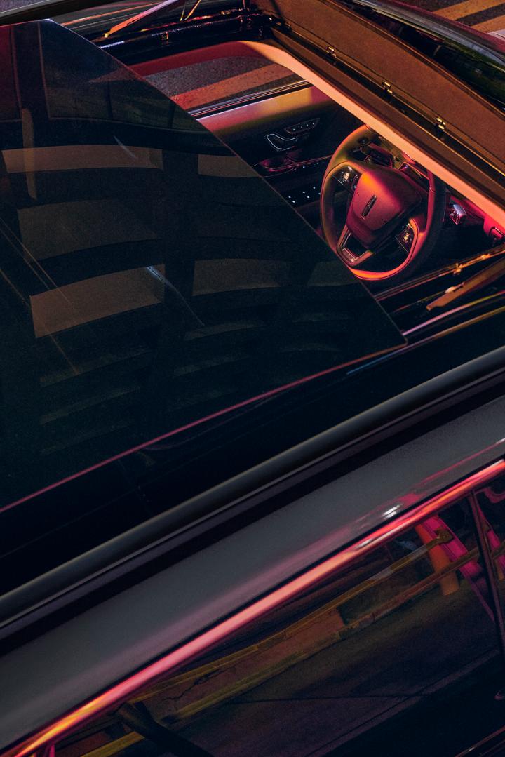 Neon light pours through the available panoramic Vista Roof® of a 2026 Lincoln Corsair