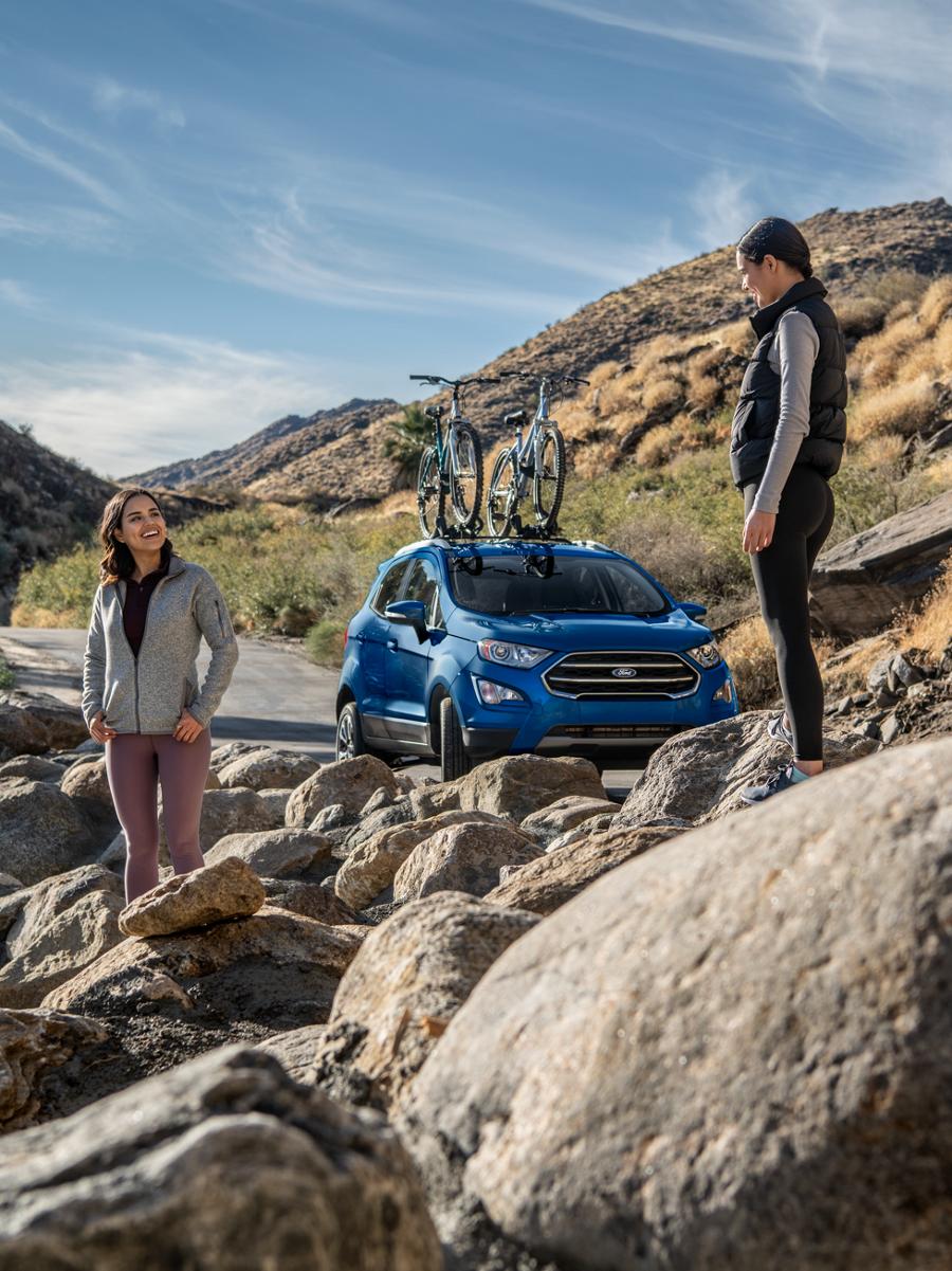 Deux jeunes femmes debout dans un paysage rocheux près d’un VUM Ford