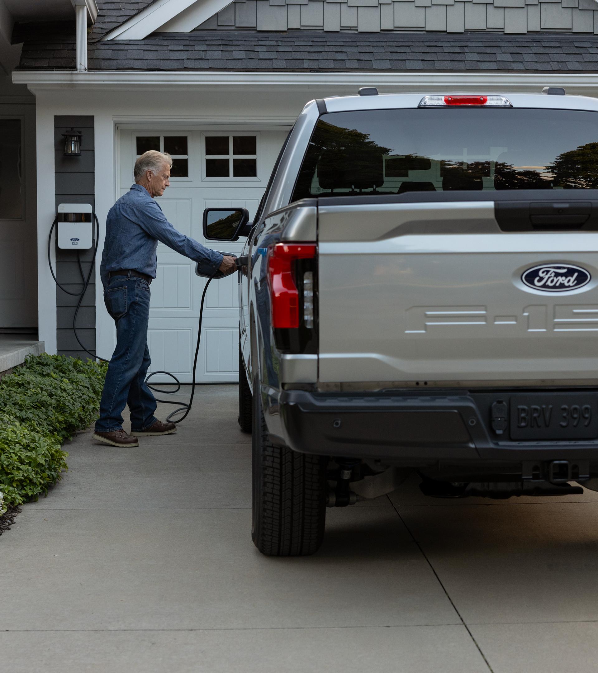 A Ford F-150 Lightning® truck owner plugs their truck into their home charger