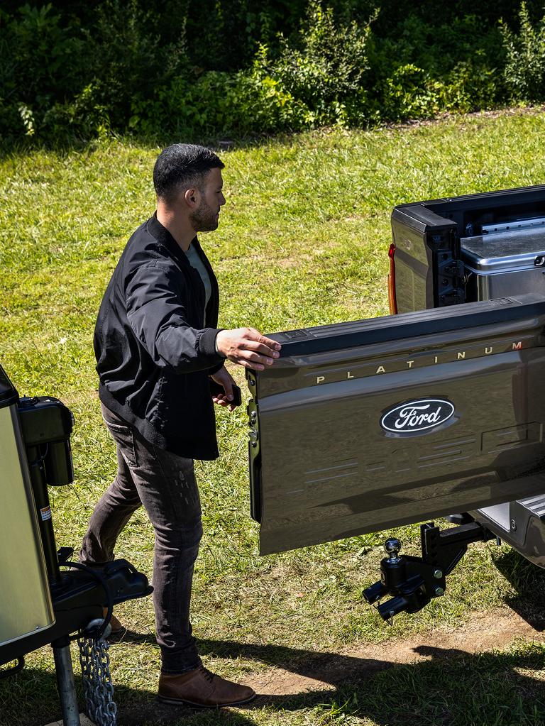 A man opening a truck bed