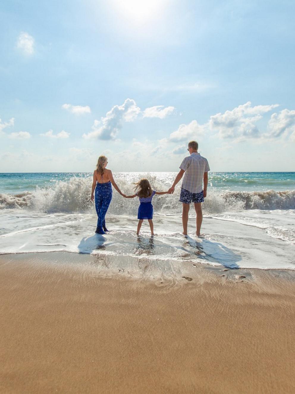Family on beach walking into water