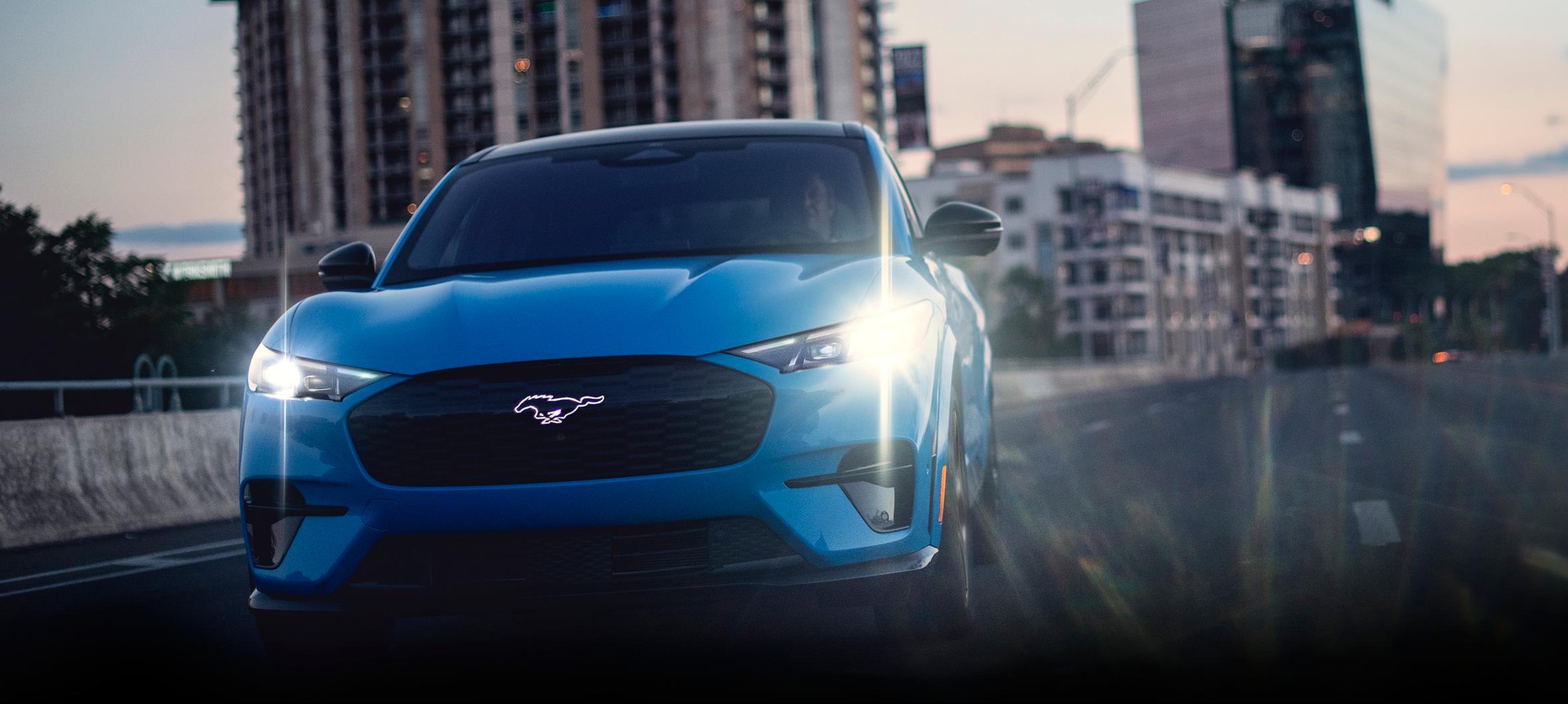 Front view of a 2026 Ford Mustang Mach-E® GT model being driven on a city freeway