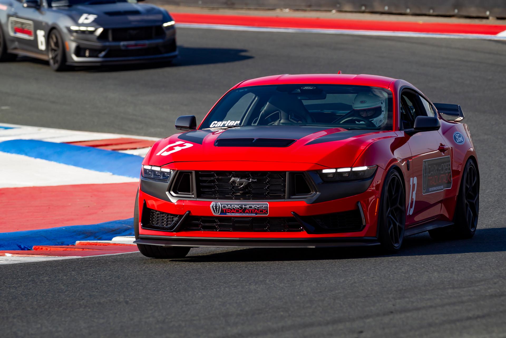 A 2026 Ford Dark Horse® Track Attack Mustang® fastback being driven on a closed course