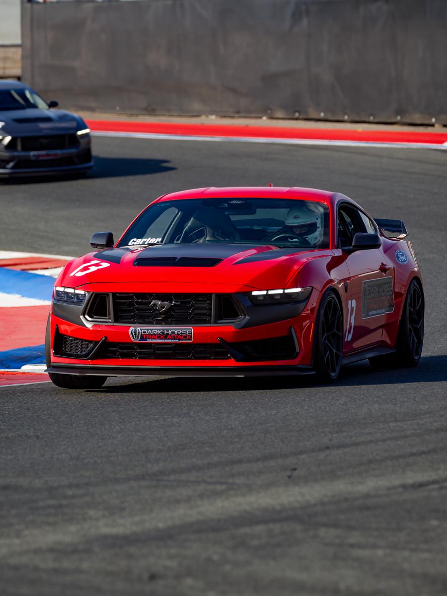 A 2026 Ford Dark Horse® Track Attack Mustang® fastback being driven on a closed course