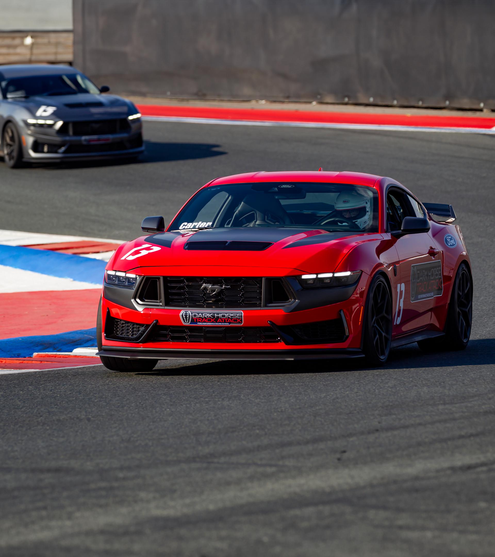 A 2026 Ford Dark Horse® Track Attack Mustang® fastback being driven on a closed course