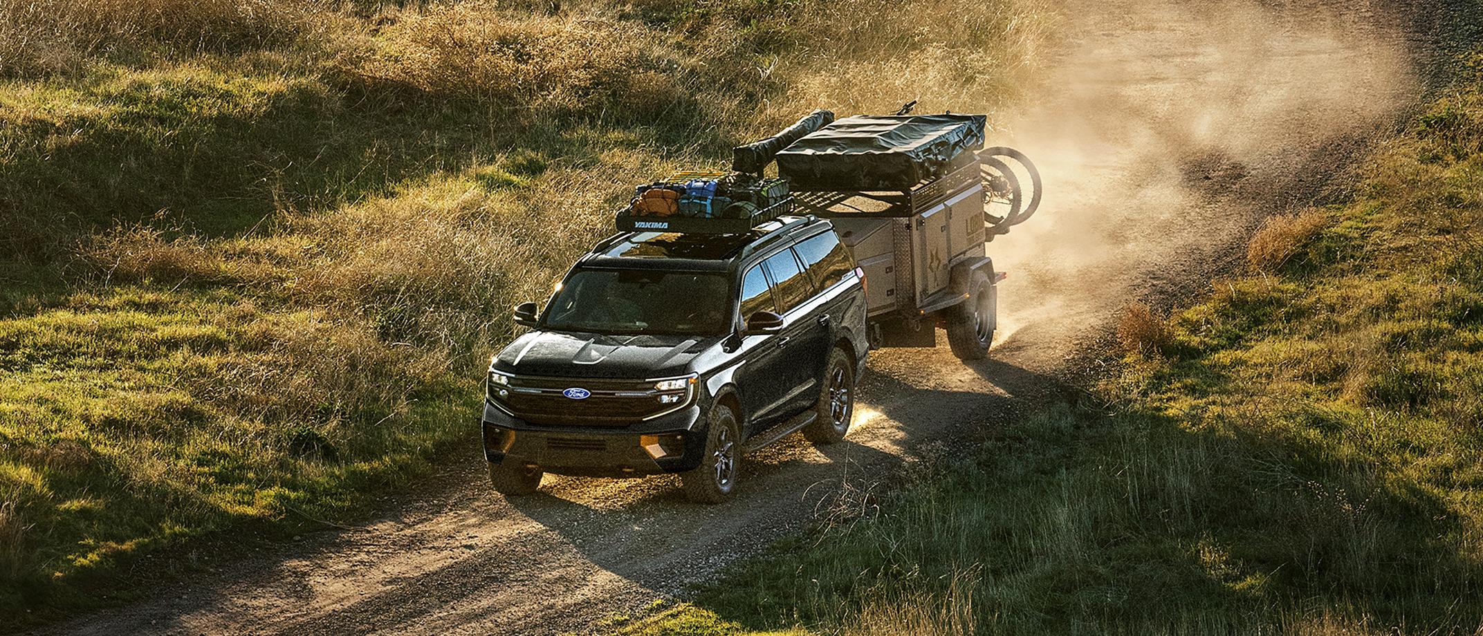 A 2027 Ford Expedition® Tremor® model being driven in the desert while towing a trailer
