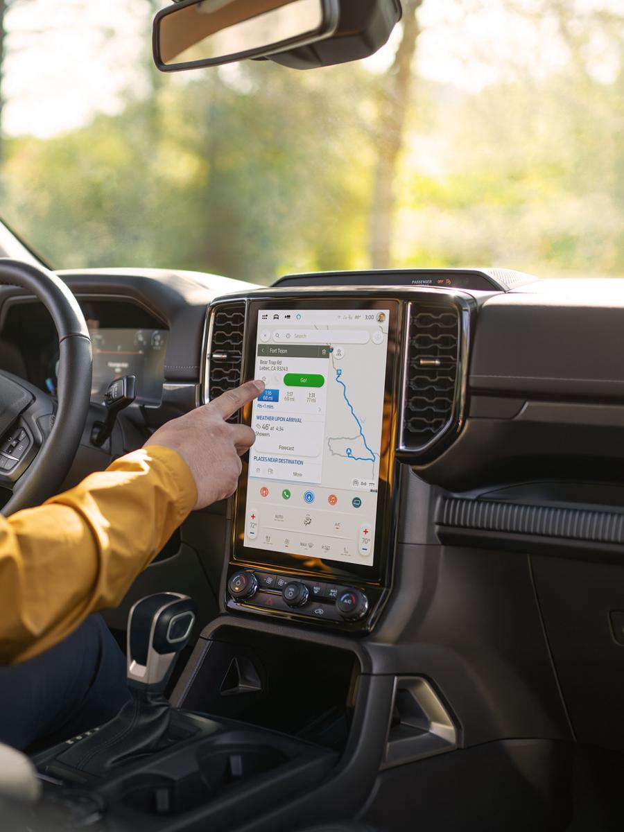 A person's hand using the 12-inch center display inside their 2026 Ford Ranger® Lariat® truck