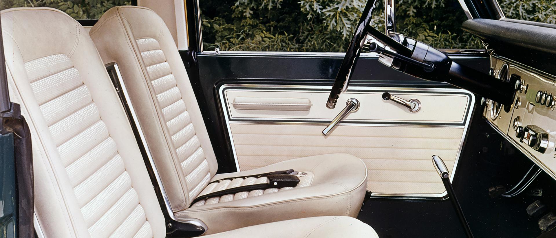 The interior front seats, steering wheel, and front dashboard of a 1967 Ford Bronco® model