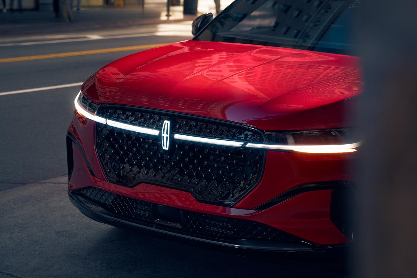 The front angle of a red colored Lincoln vehicle.