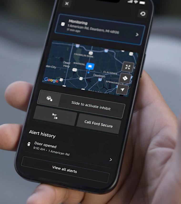 Close-up of a person holding a phone, displaying the Ford Security map features