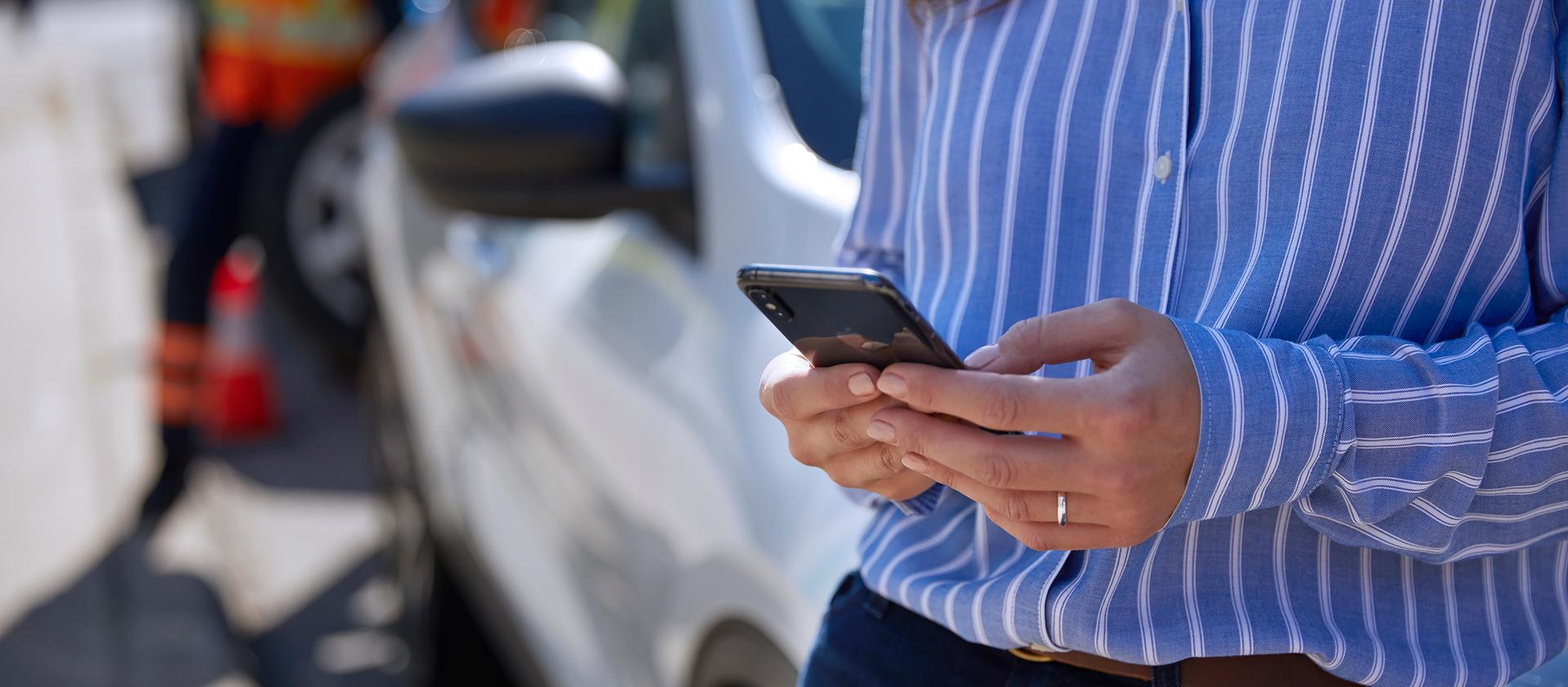 A person on their phone at the scene of an accident