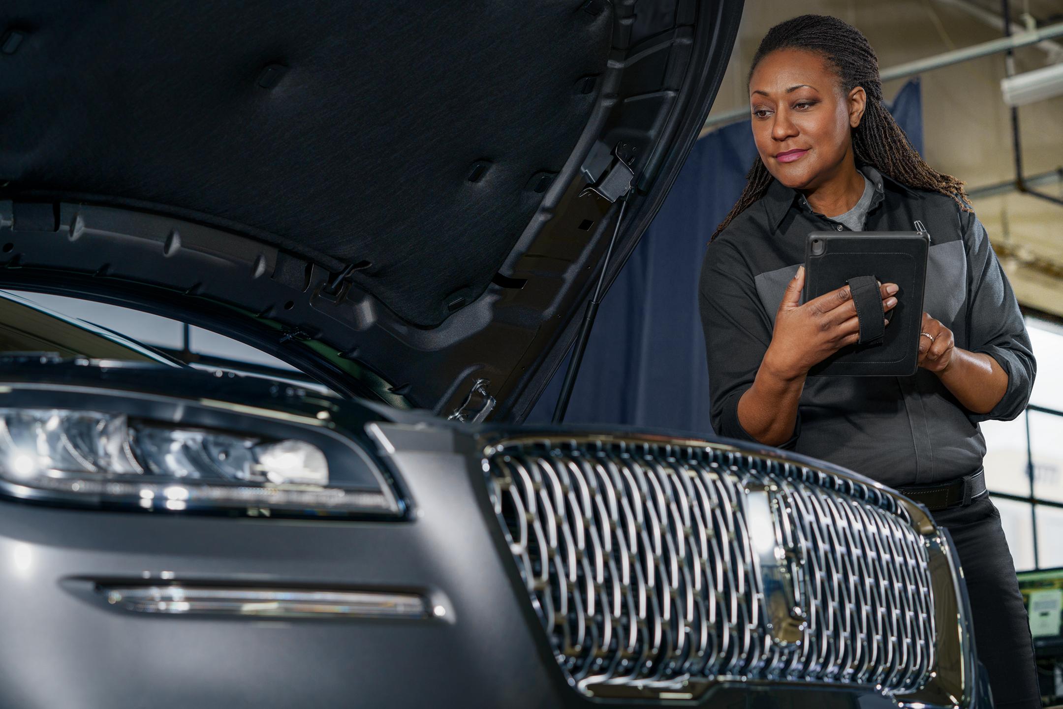 A Lincoln technician is inspecting a Lincoln vehicle.