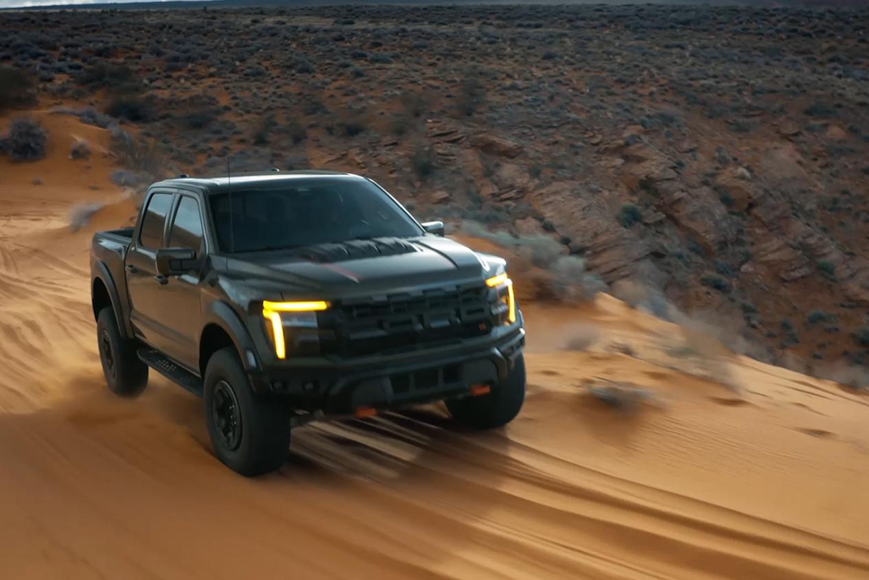 A black 2026 Ford F-150® Raptor® R™ confidently navigates a high dirt ridge in the desert