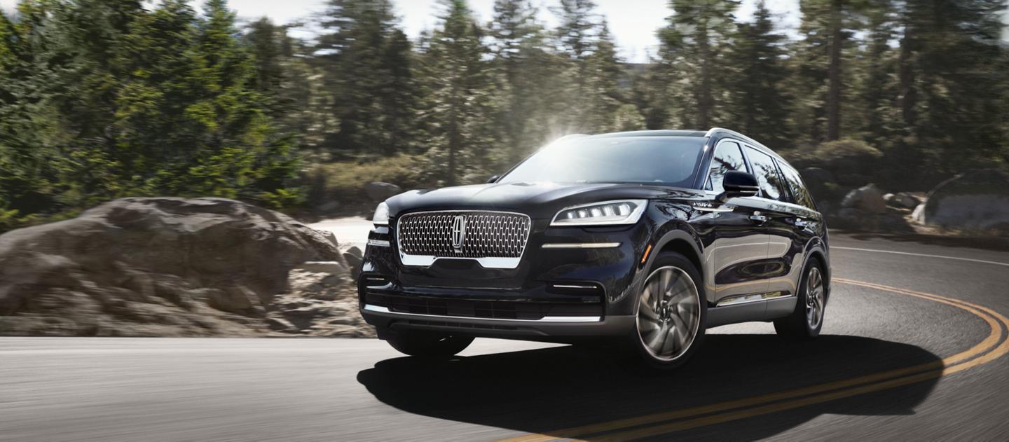 The 2024 Lincoln Aviator driving down a winding road.
