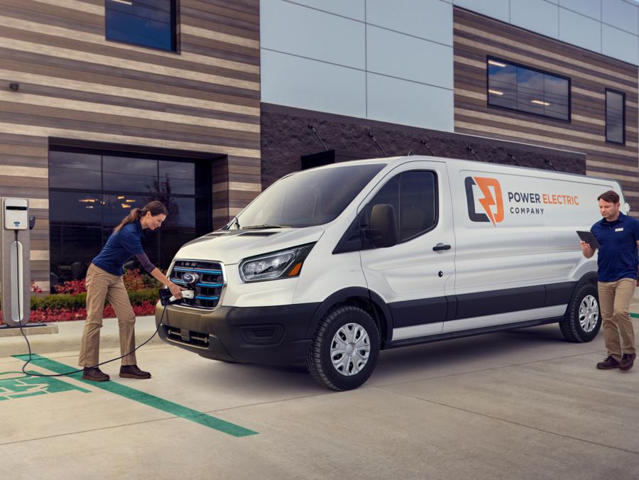 A 2023 E-Transit Van outside a building being plugged in